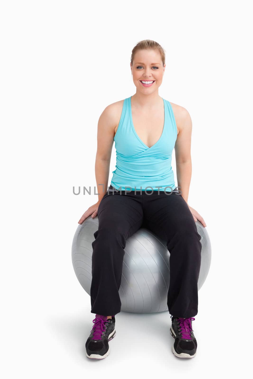 Woman on a swiss ball against white background