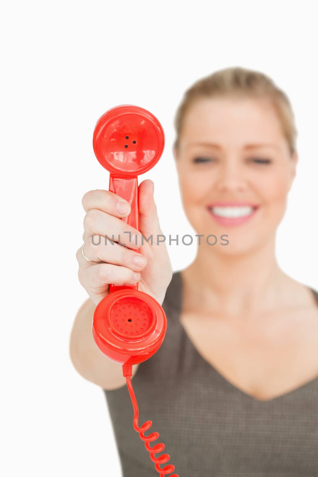 Blurred woman showing a retro phone against white background