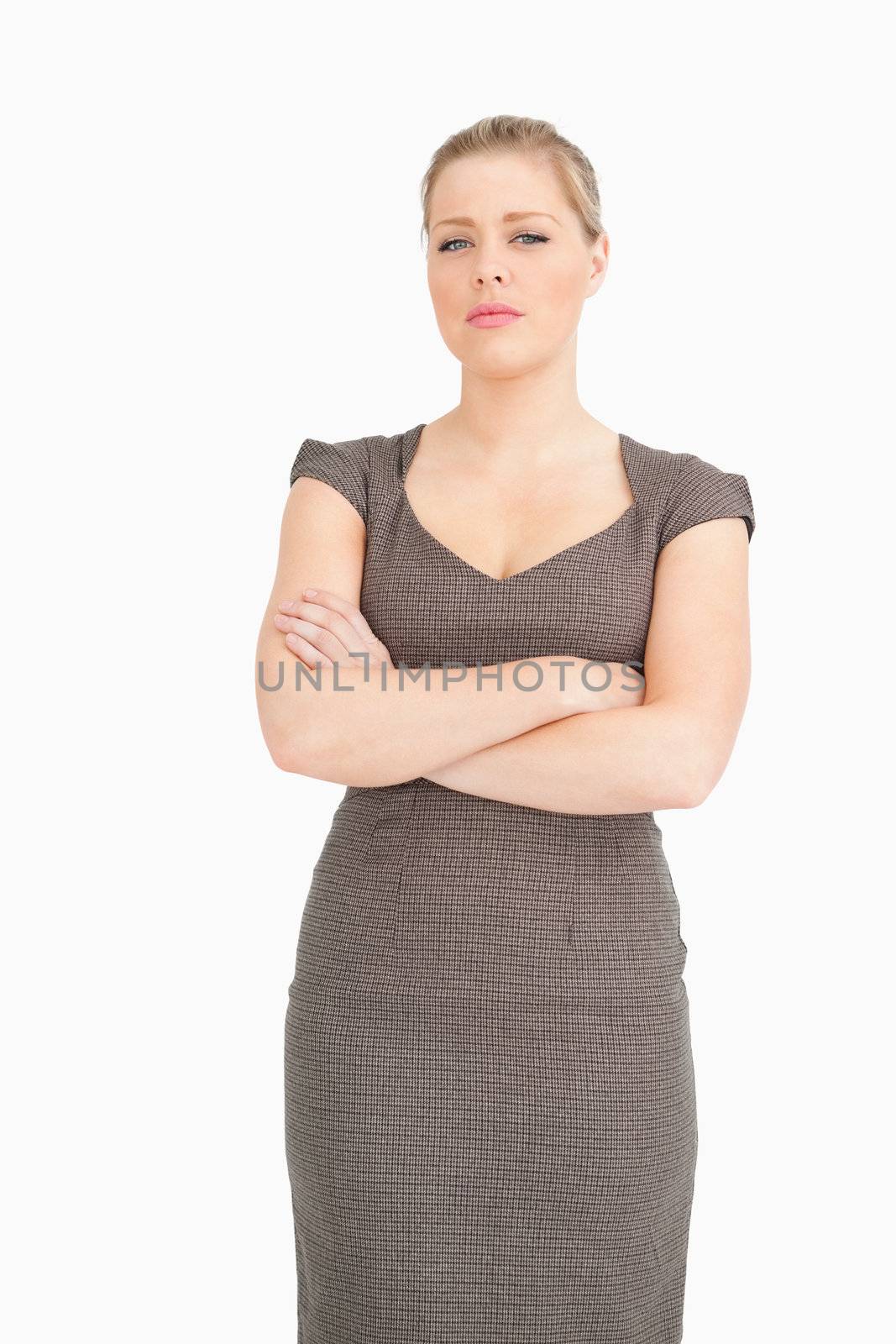 Serious woman standing with arms crossed against white background