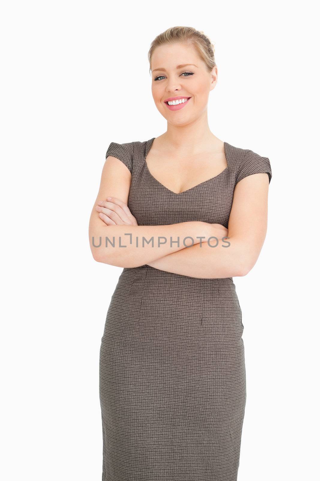 Woman standing with arms crossed against white background
