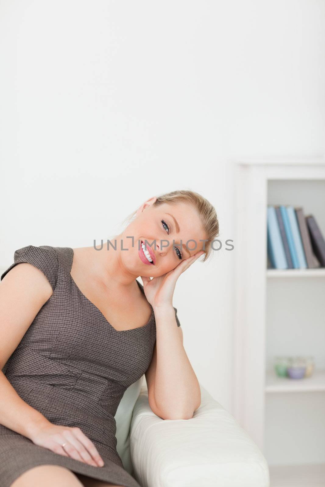 Woman sitting on a sofa with an arm on armrest in a lounge
