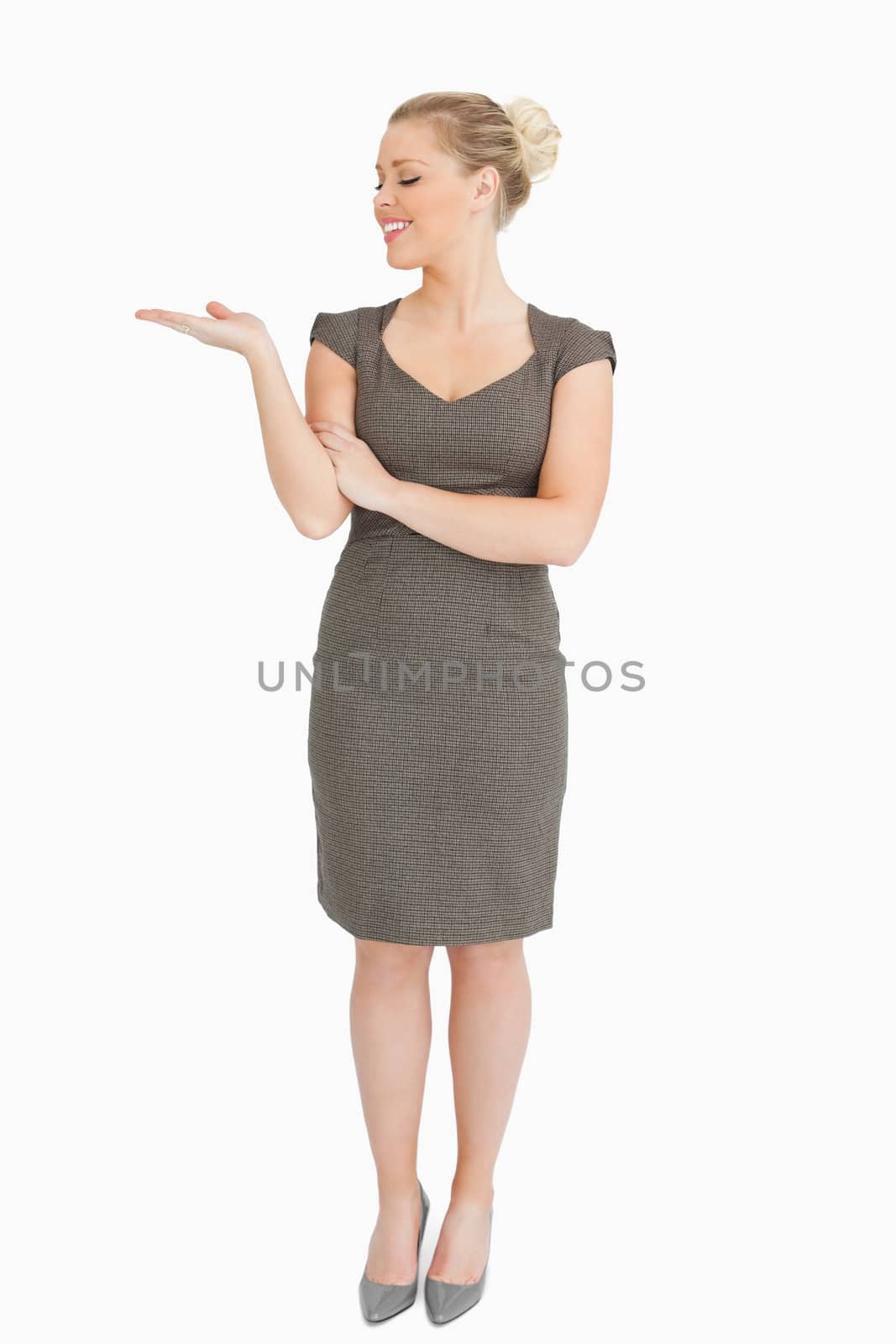 Woman looking her hand presenting something against white background