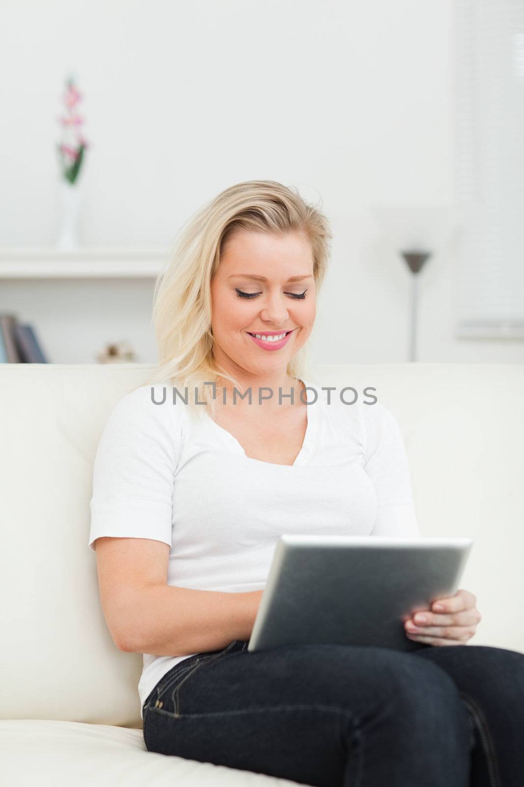 Casual woman touching a screen of an ebook on a living room