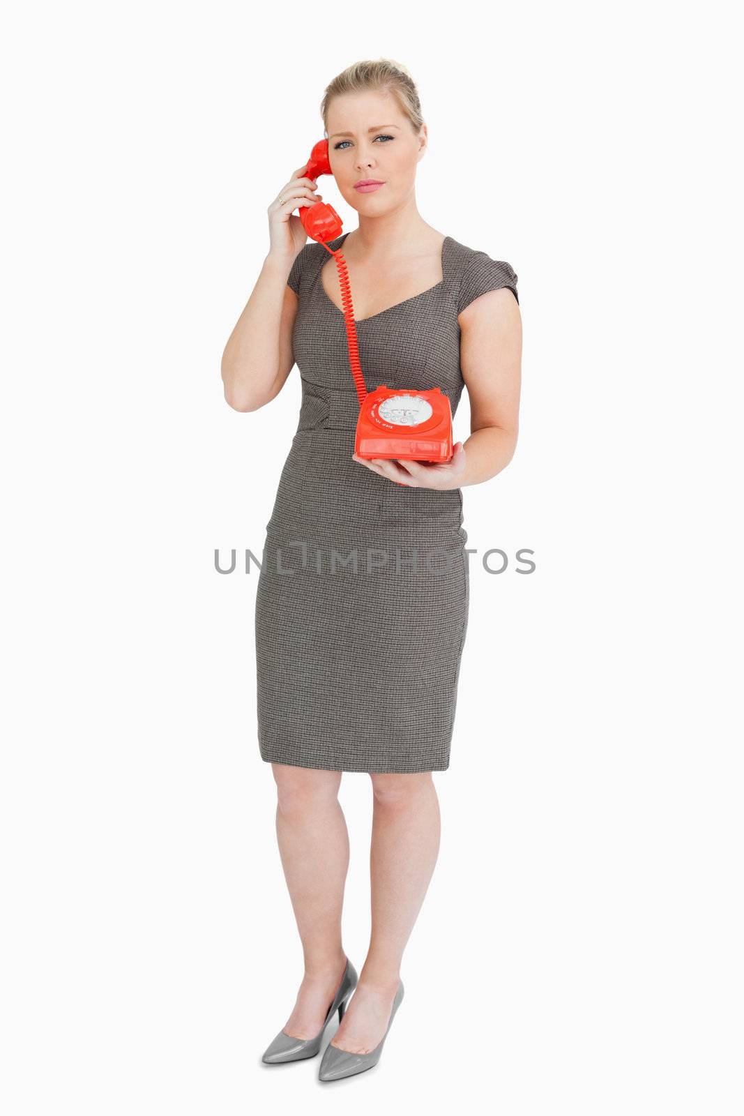 Serious woman calling with a retro phone against white background