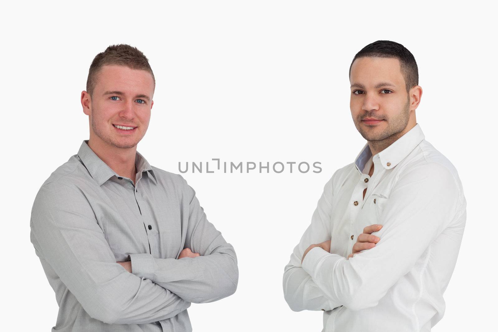 Two men crossing arms and standing side by side against a white background