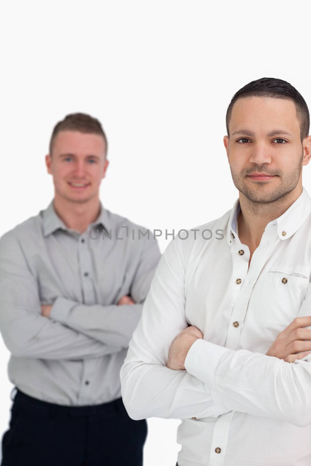 Two men crossing their arms as they stand up against a white background