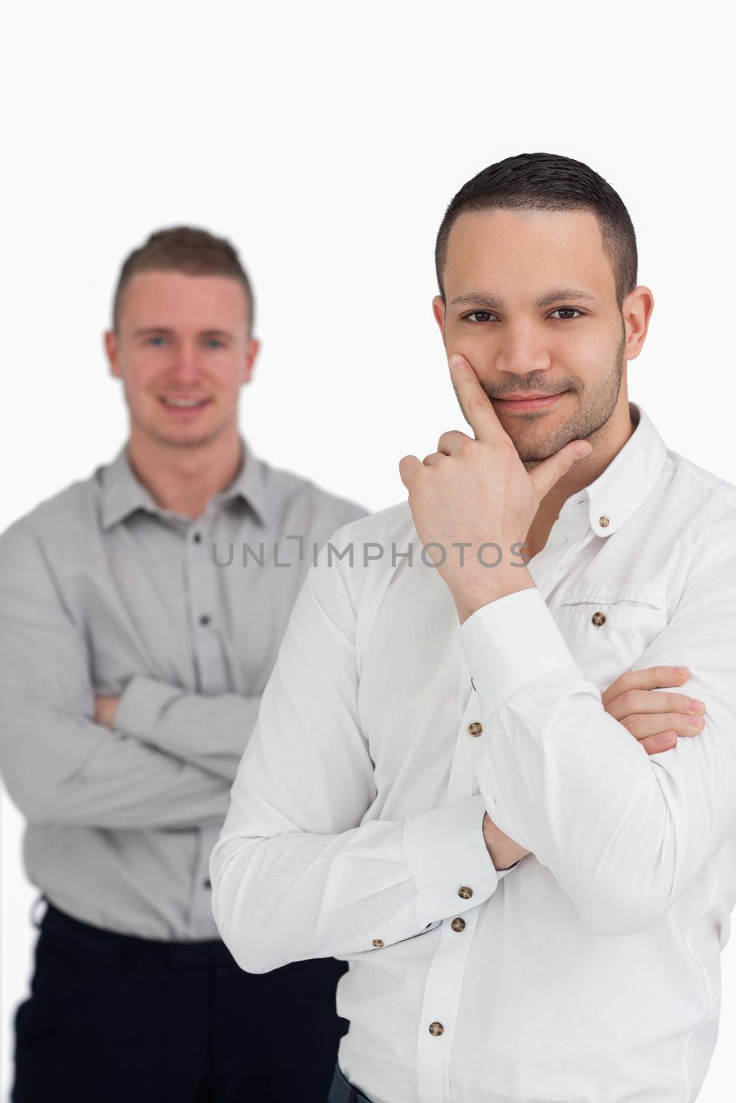Two men crossing their arms against a white background