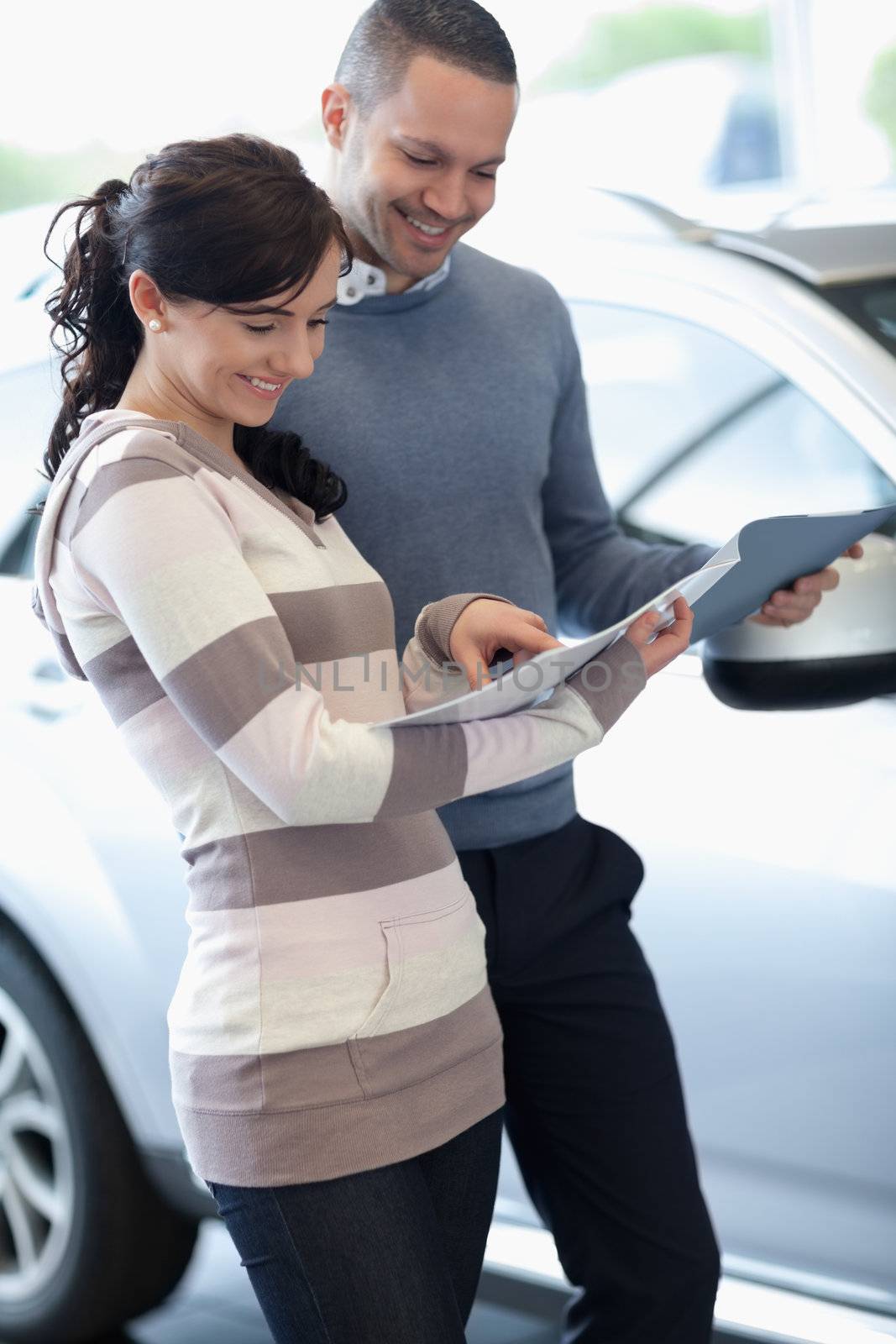 Couple holding documents in a carshop