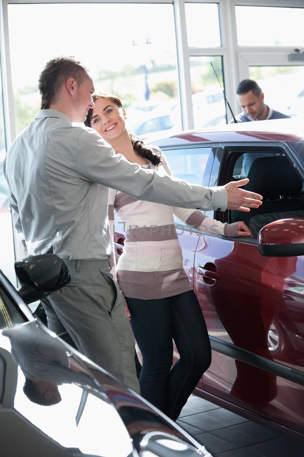 Woman talking with a salesman in a car shop