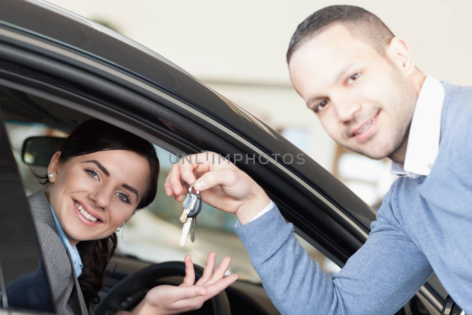 Man giving car keys to a woman thru a window