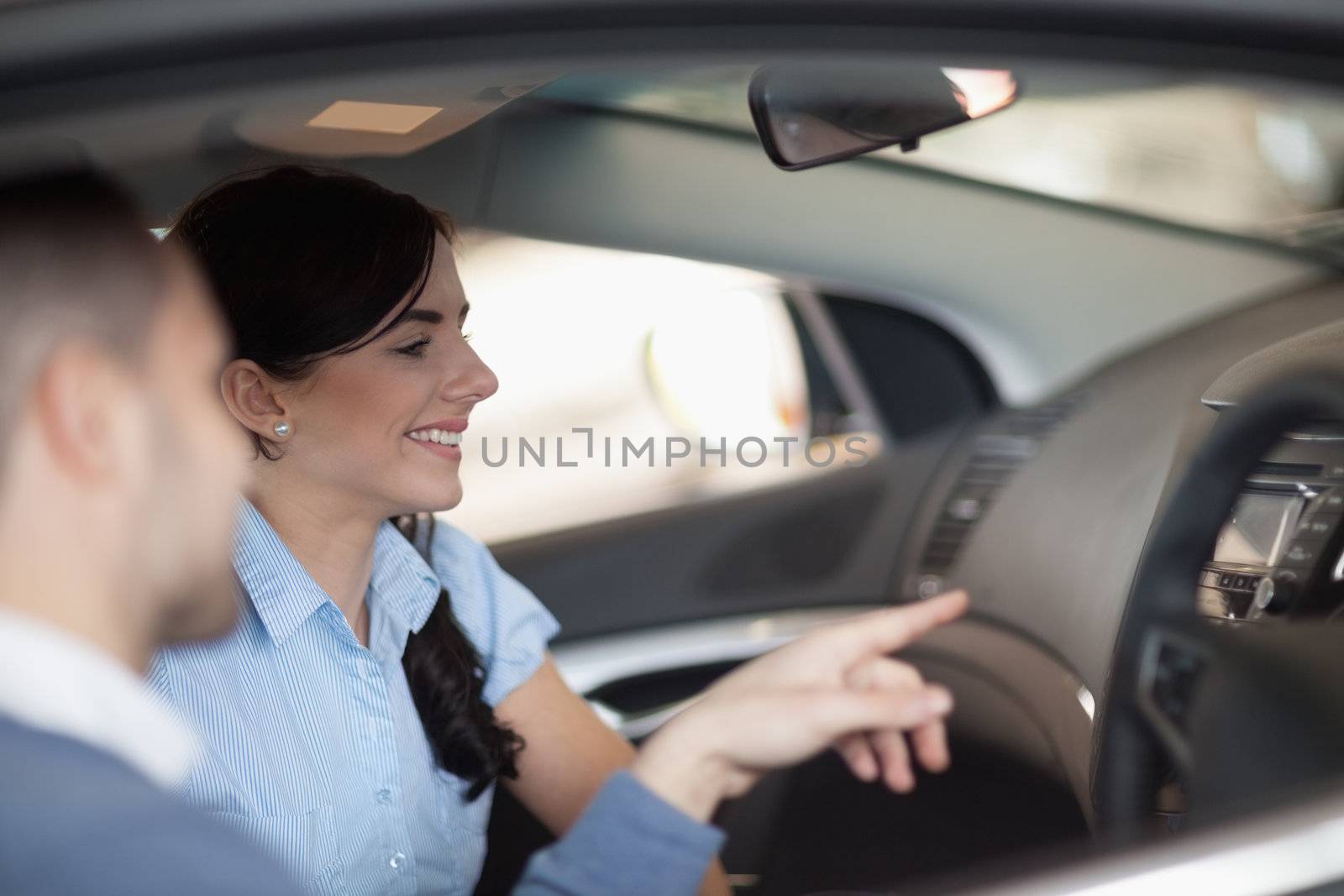 Woman looking at the interior of a car while sitting in it