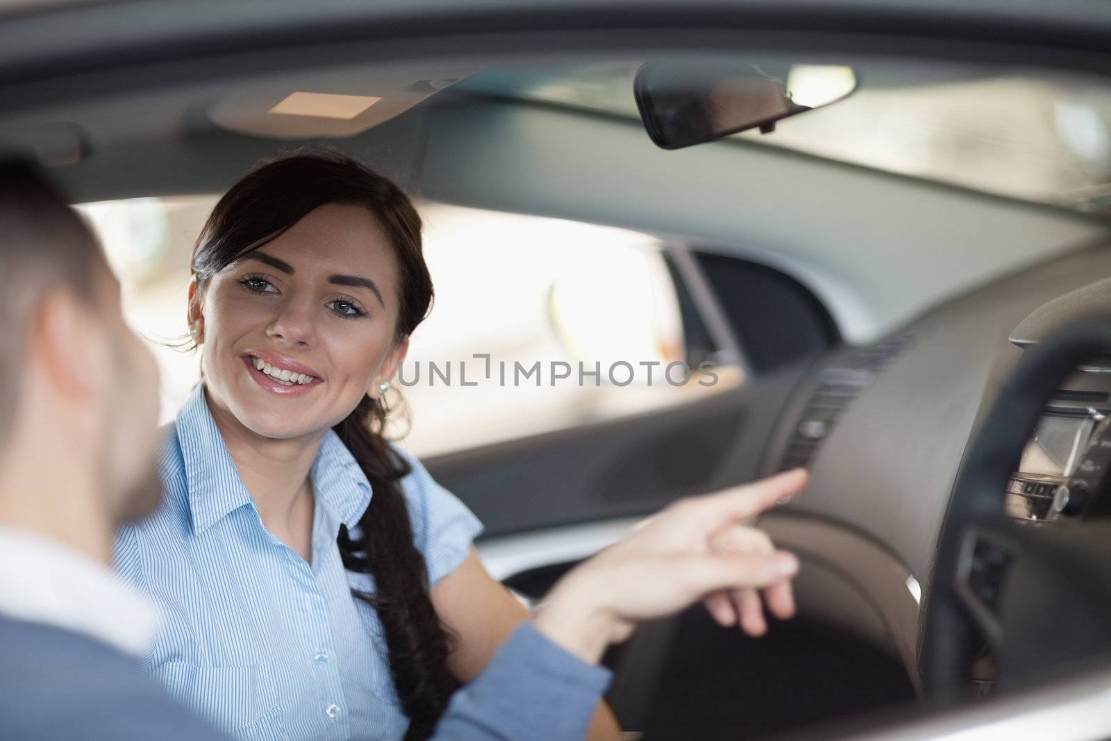 Man pointing a car interior while sitting in a car