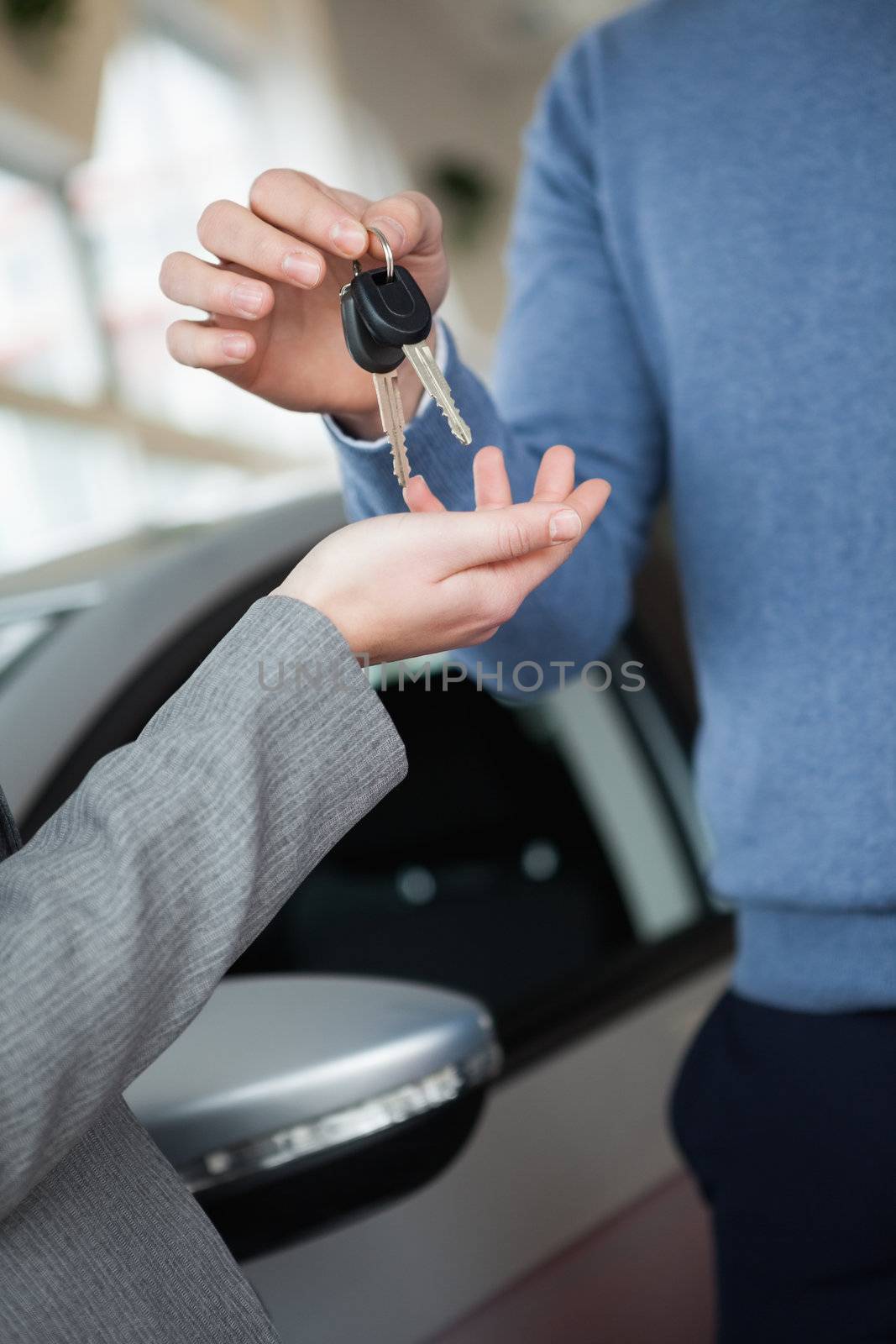 Woman receiving keys from a man in a car shop