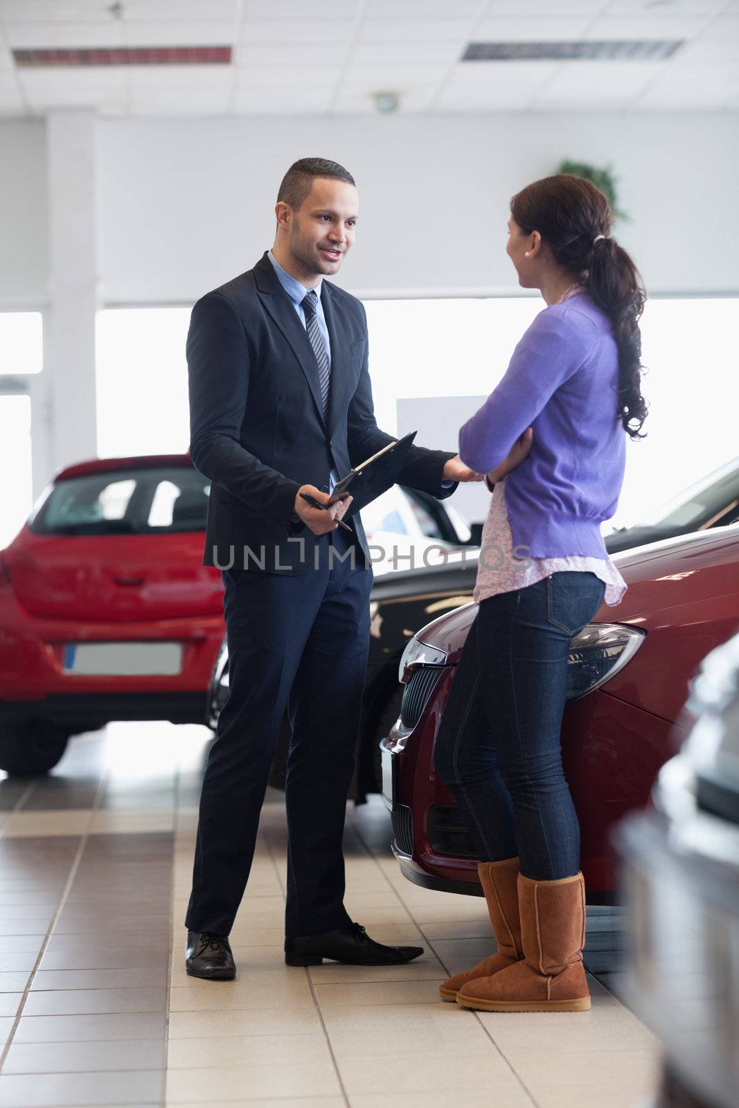 Salesman talking to a customer in a car shop