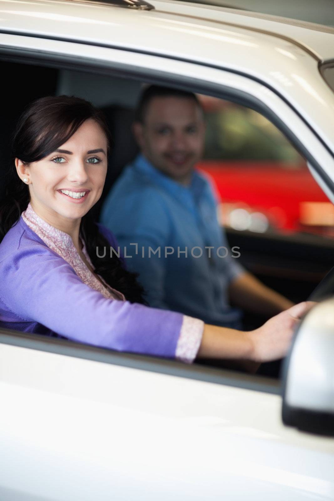 Happy couple in a car while smiling