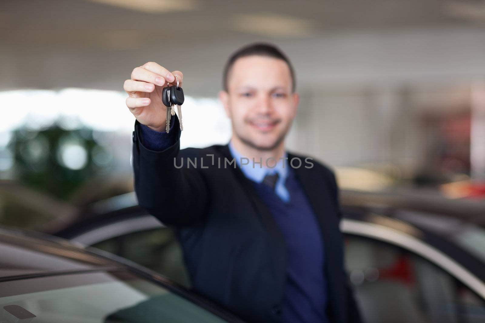 Dealer standing while holding car keys in a dealership