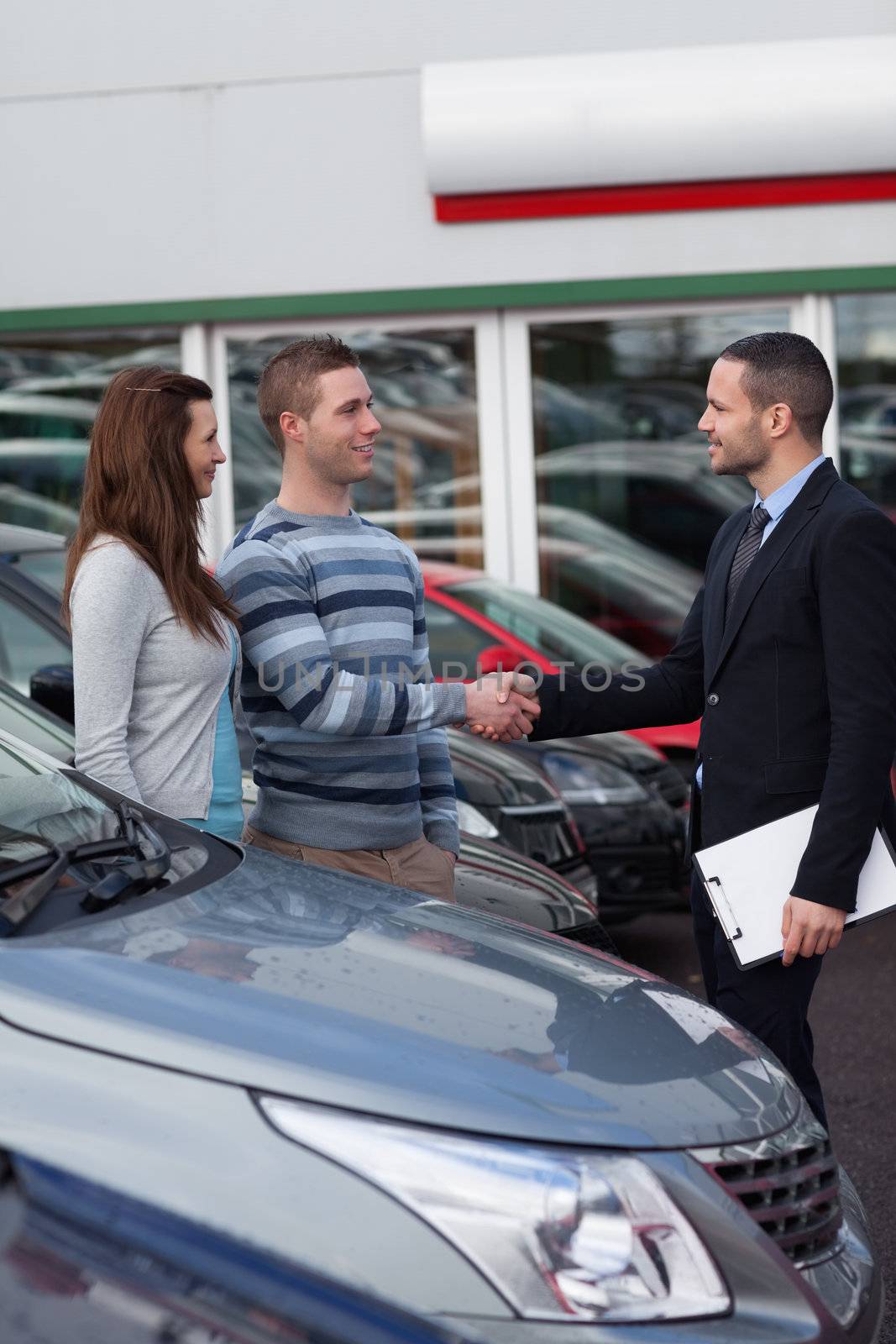 Businessman shaking hand  of a man in a dealership
