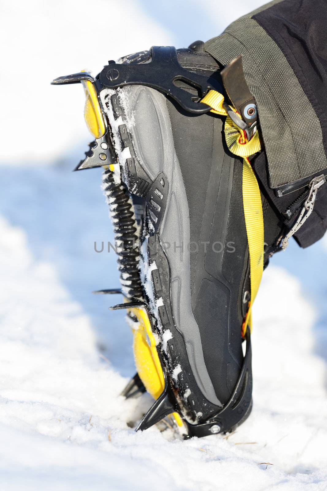 Crampons closeup. Crampon on winter boot for climbing, glacier walking or hiking and trekking on ice and hard snow.