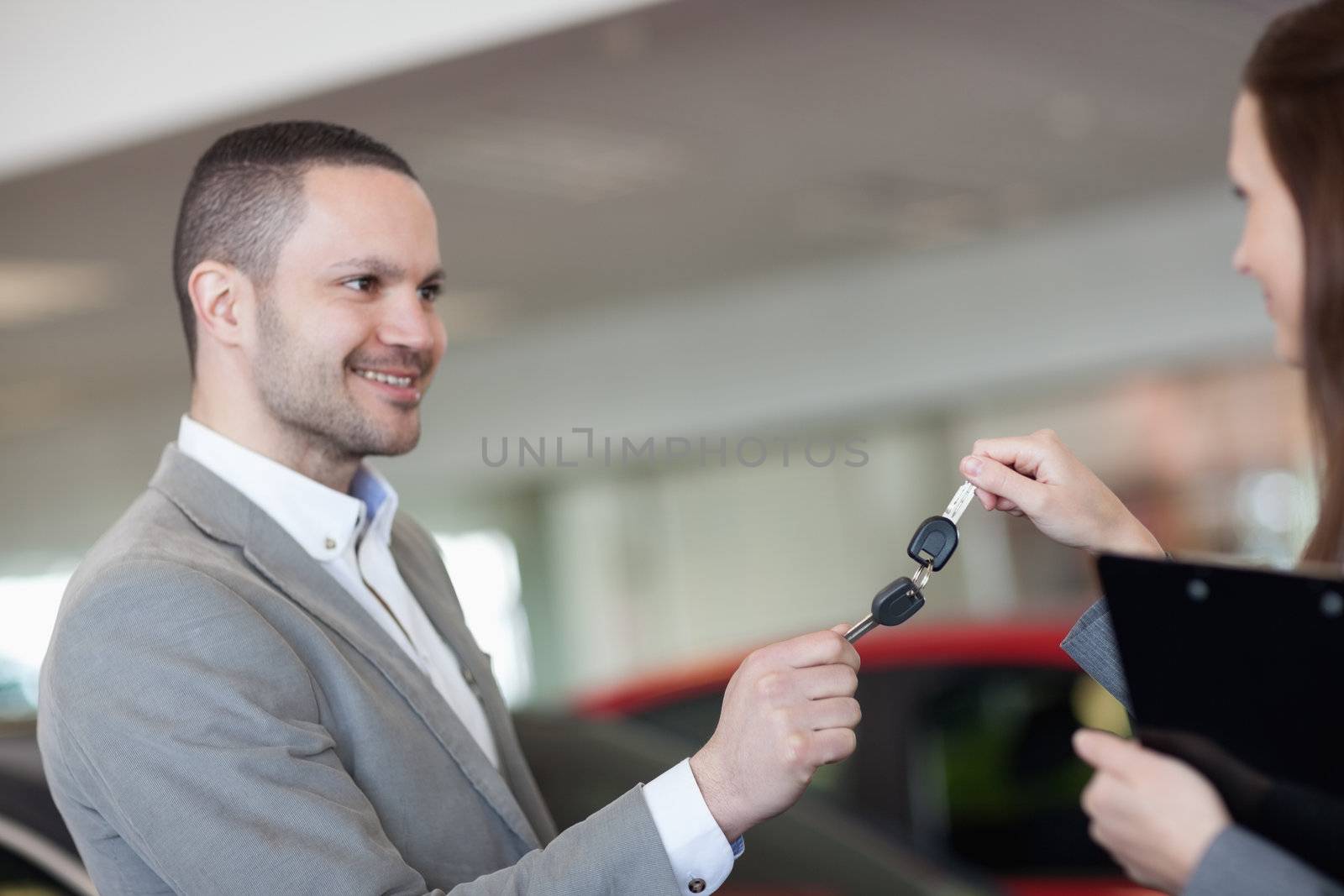 Businesswoman and man holding car keys in a garage