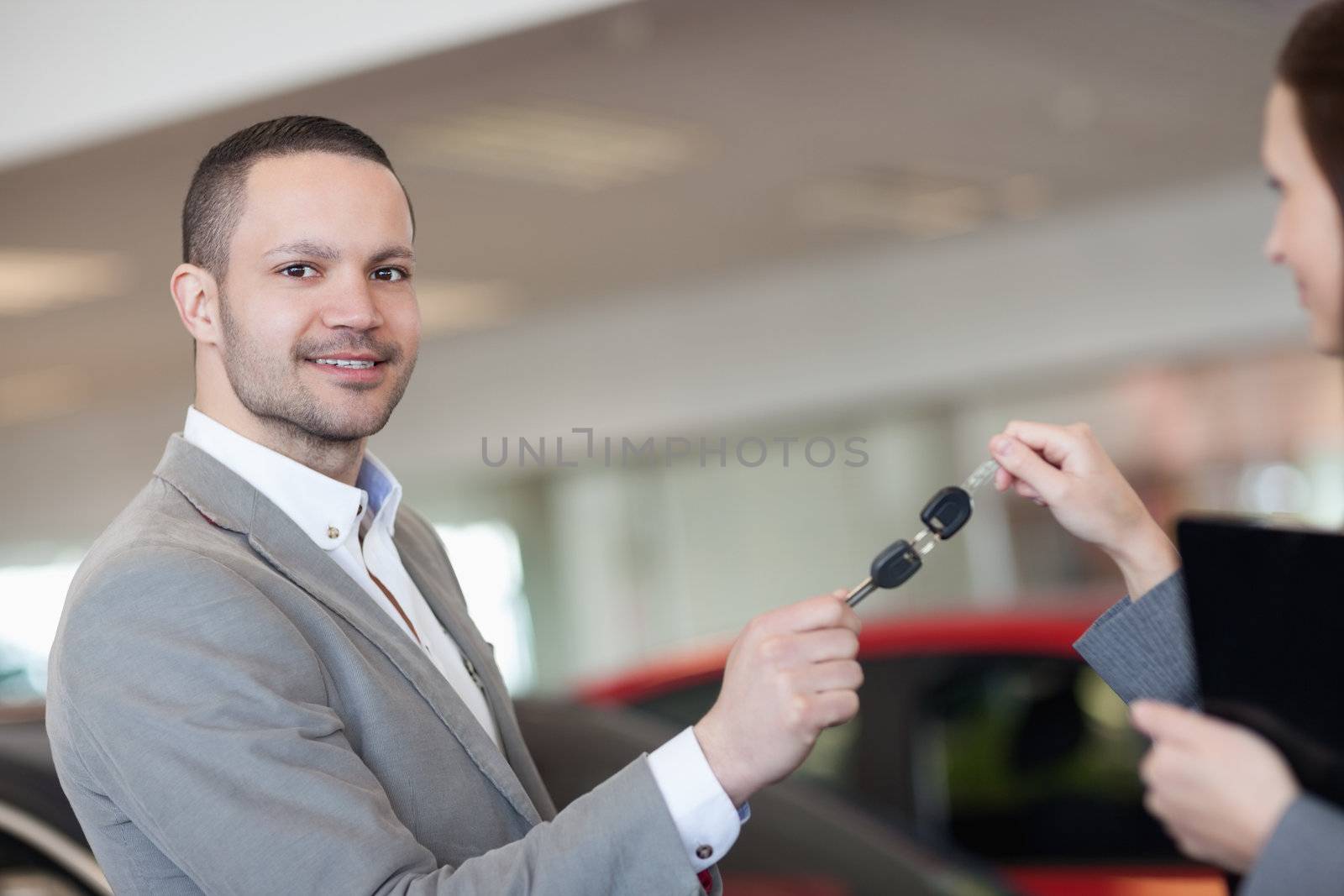 Man holding car keys with a businesswoman in a garage