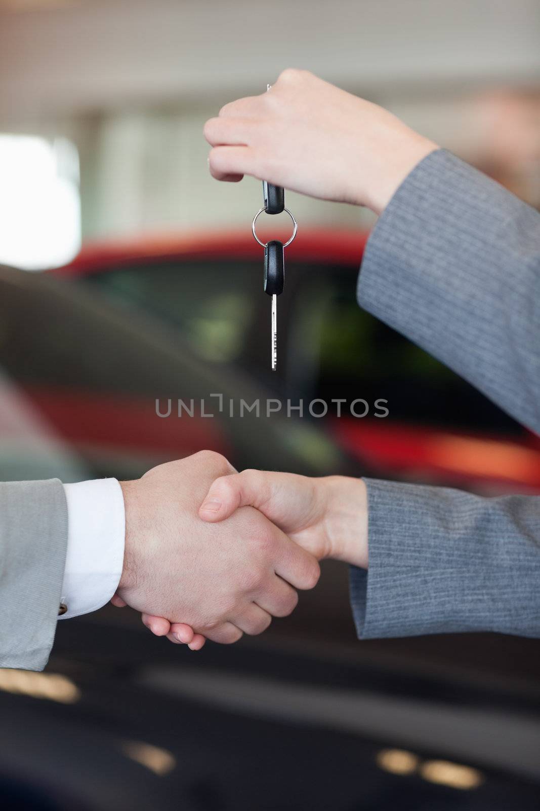 Close up of a woman giving car keys to a man by Wavebreakmedia