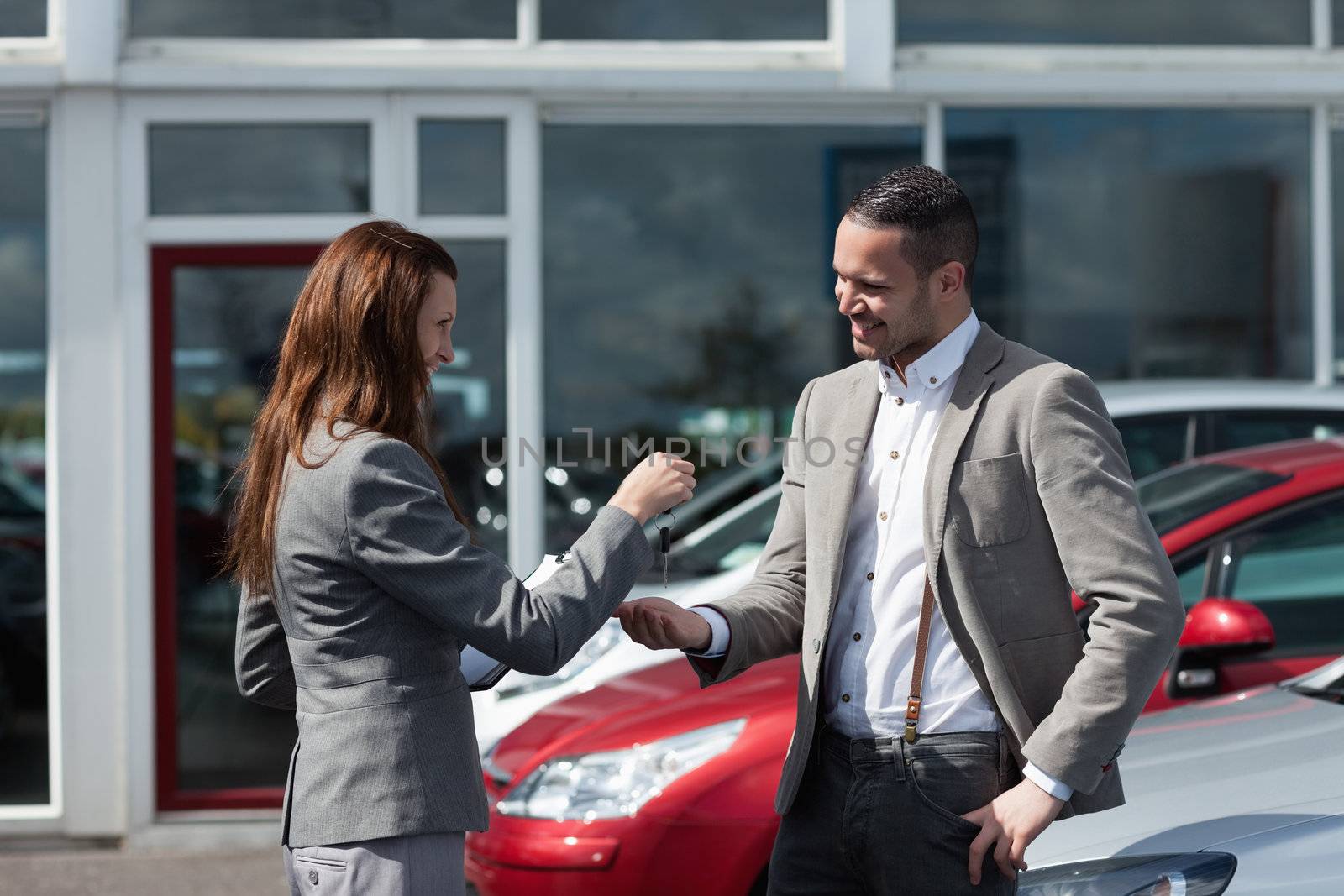 Businesswoman giving car keys to a man in a garage