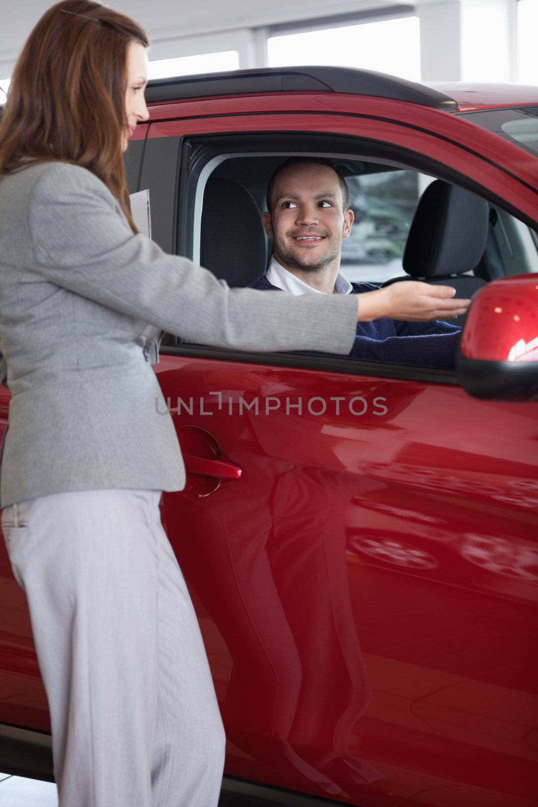 Businesswoman showing something to a man in a dealership