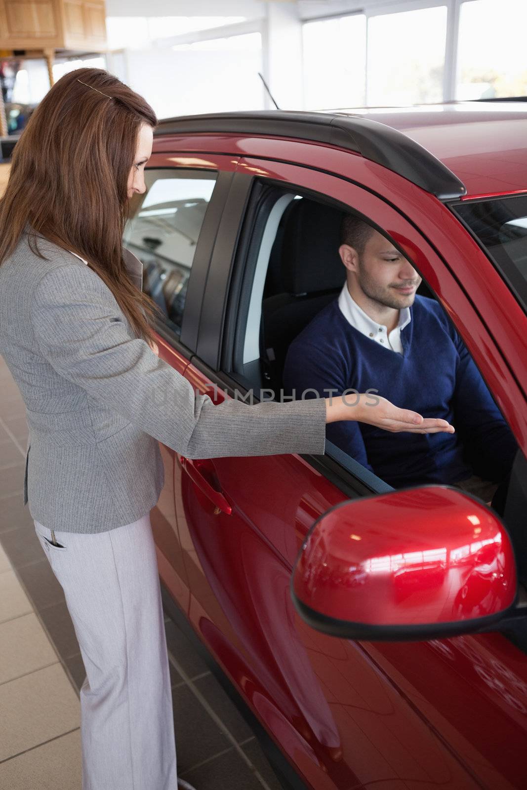 Woman presenting something to a client in a dealership