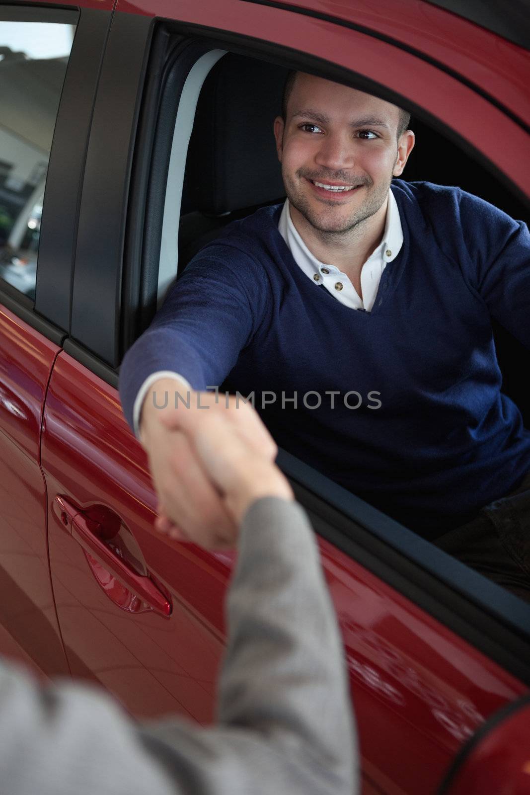 Man shaking hand of a woman in a car