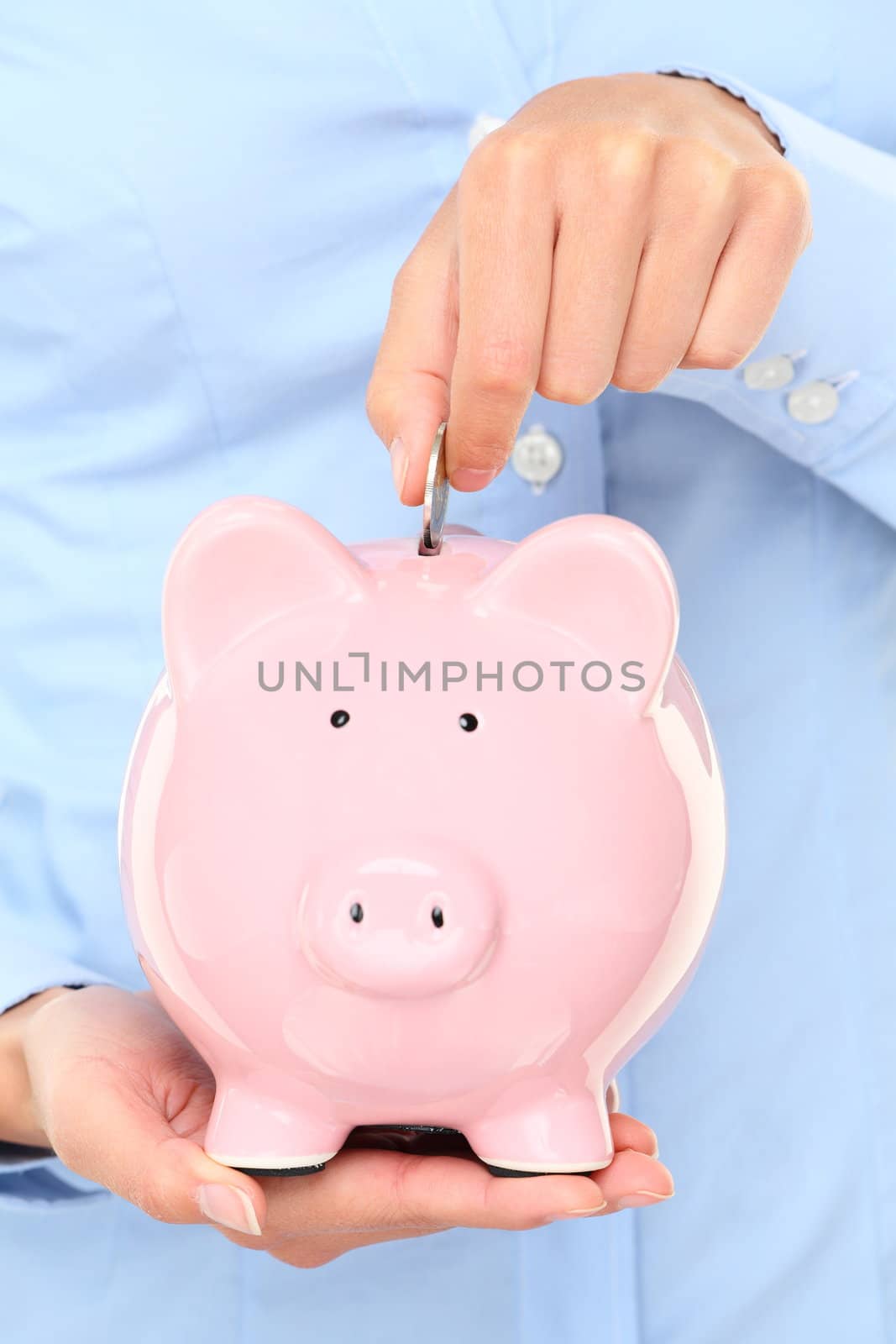 Piggybank money concept. Savings and financial concept closeup of business woman hand putting money in piggy bank savings.