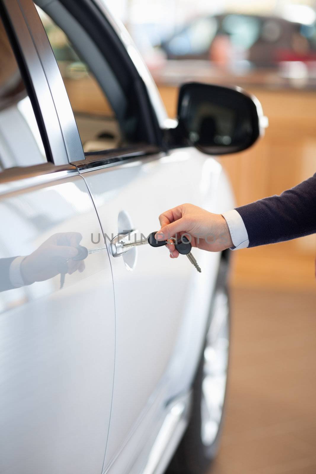 Man inserting a car key in the lock in a garage