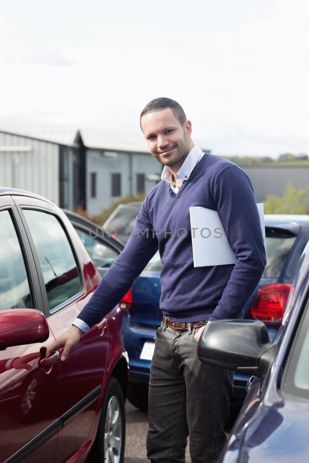 Man holding a car handle while holding a file by Wavebreakmedia