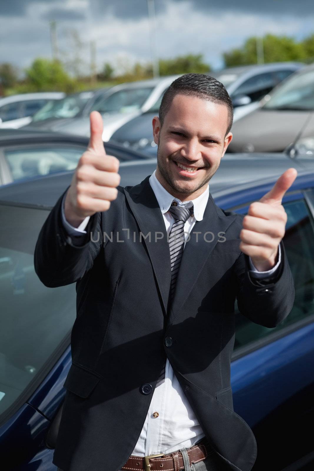Businessman raising his thumbs while smiling by Wavebreakmedia