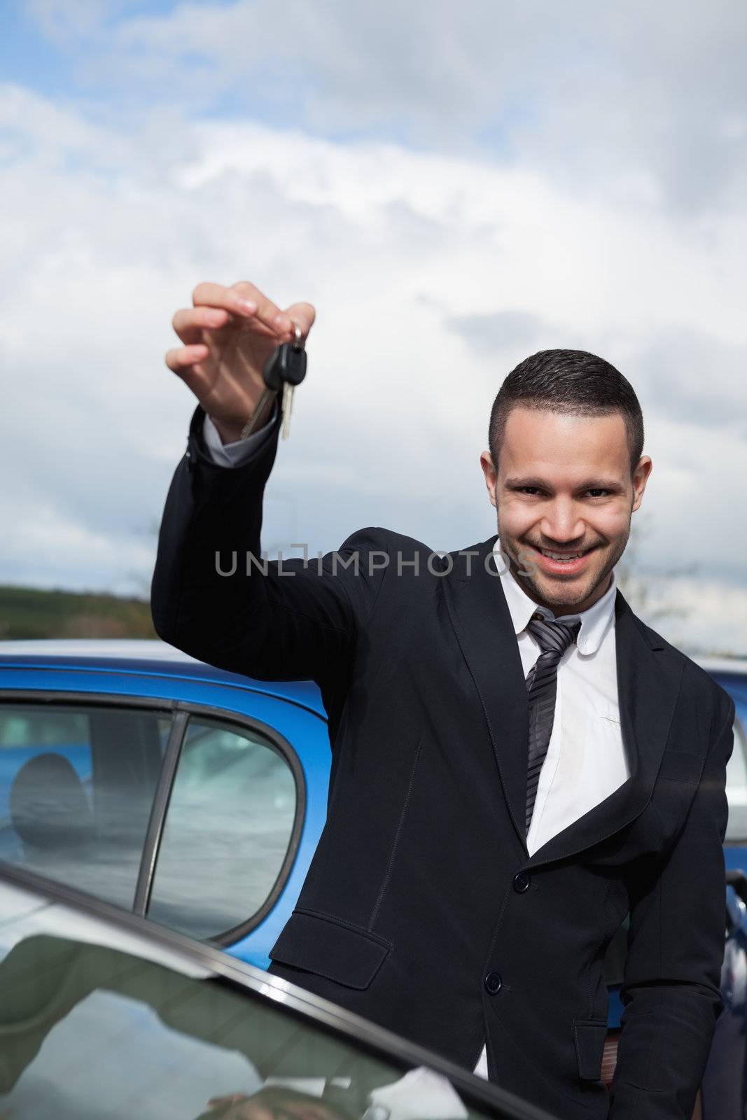 Happy man holding car keys outdoors