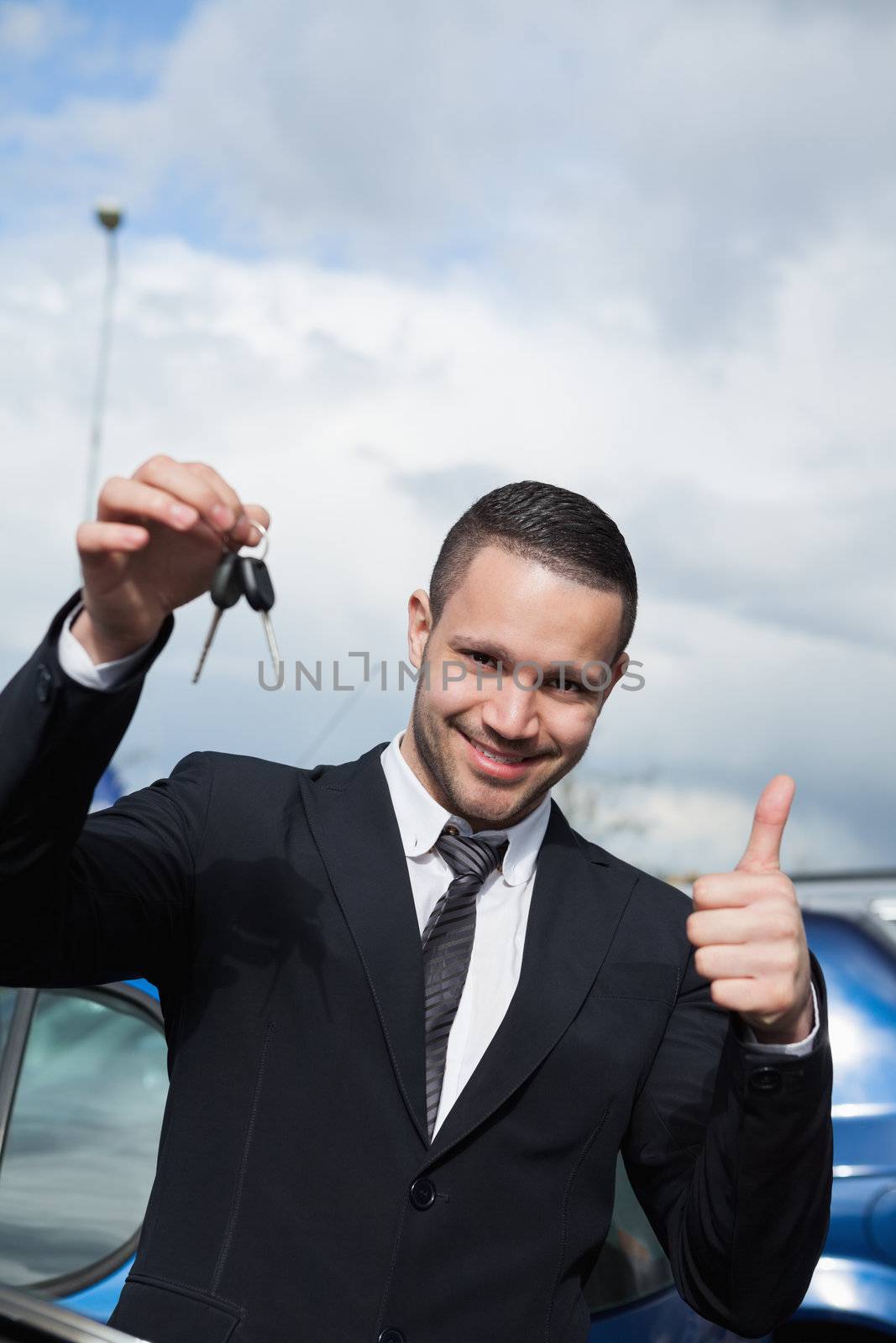 Man holding car keys while raising his thumb by Wavebreakmedia