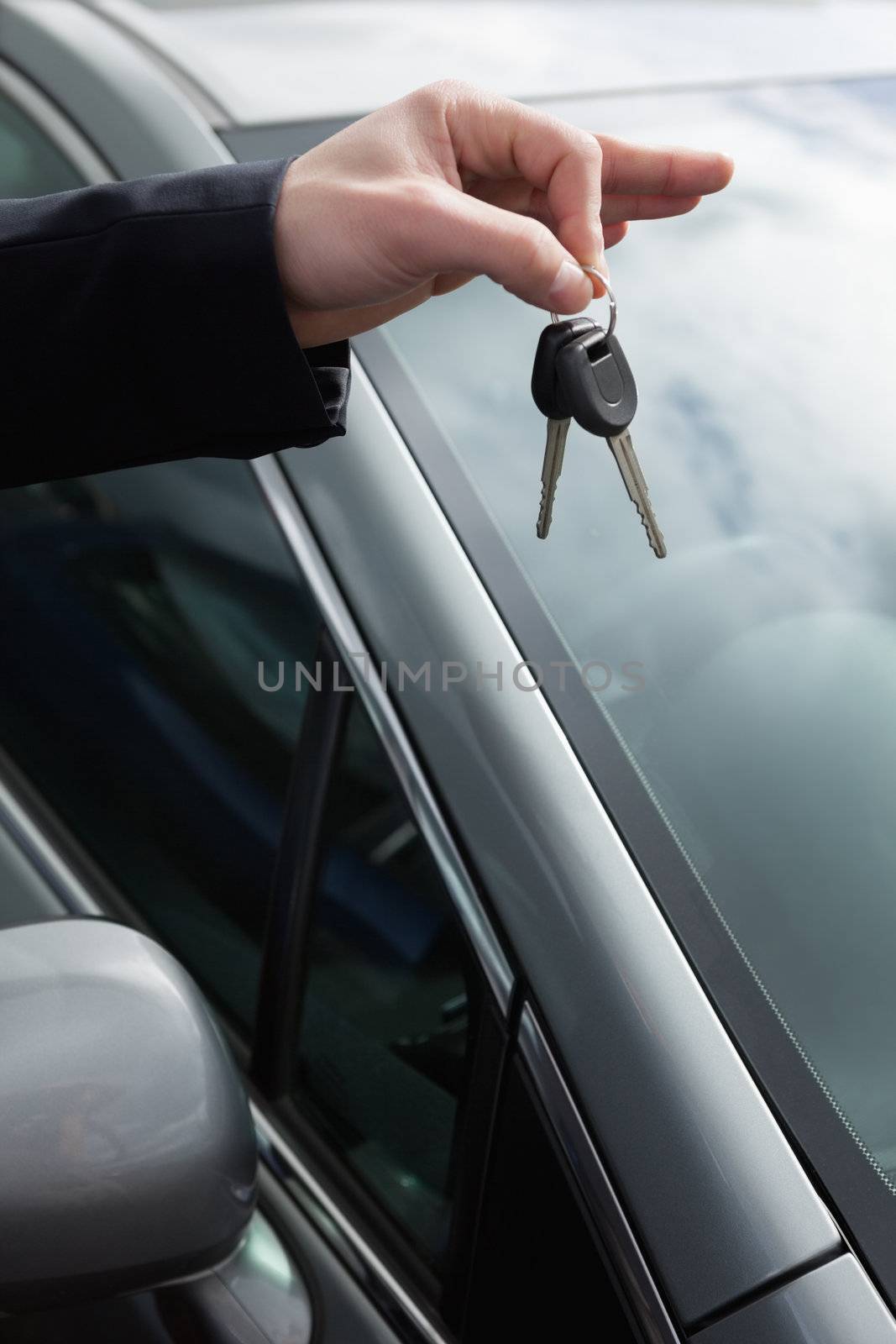 Someone holding car keys by his fingertips by Wavebreakmedia