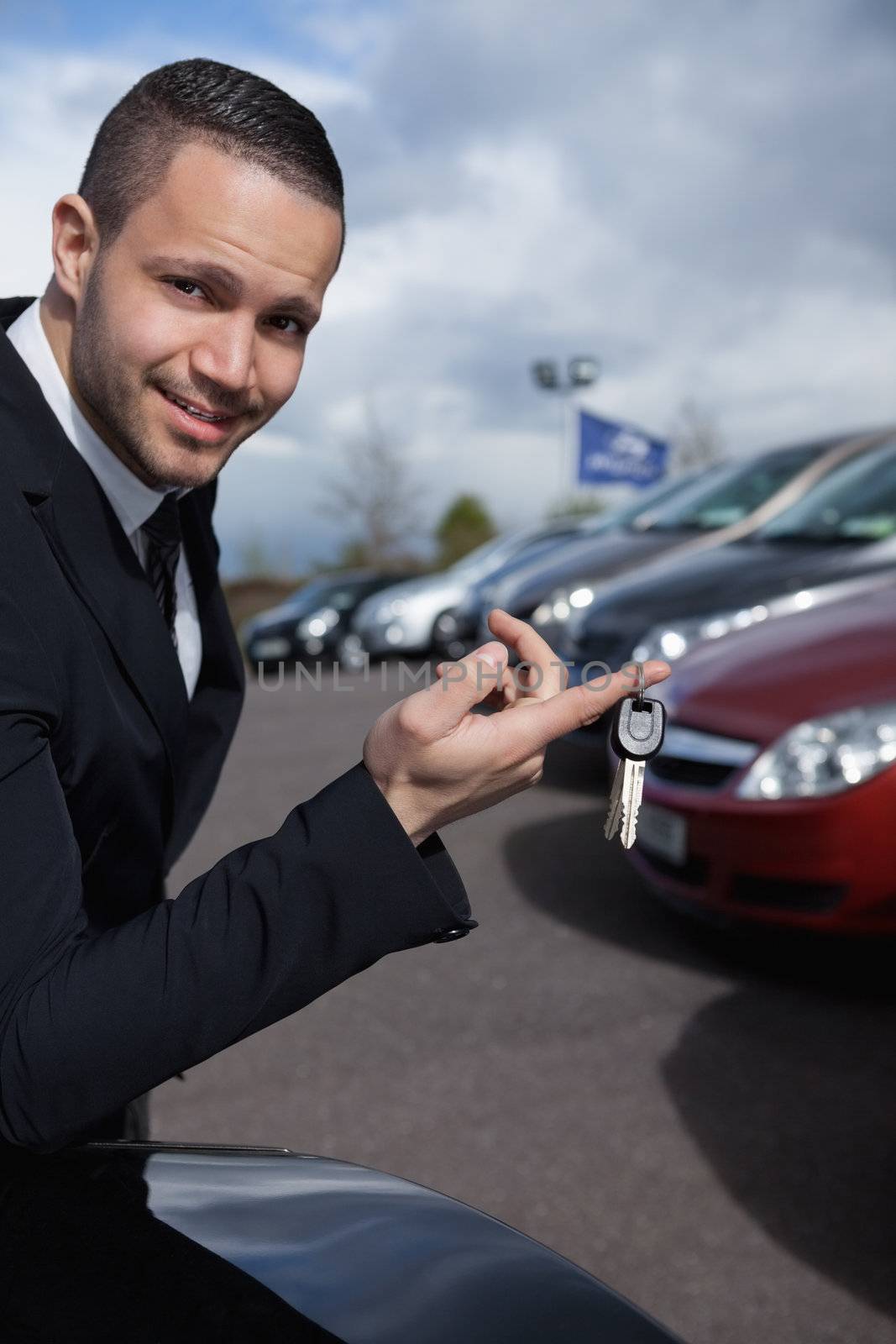 Man holding car keys with a finger outdoors