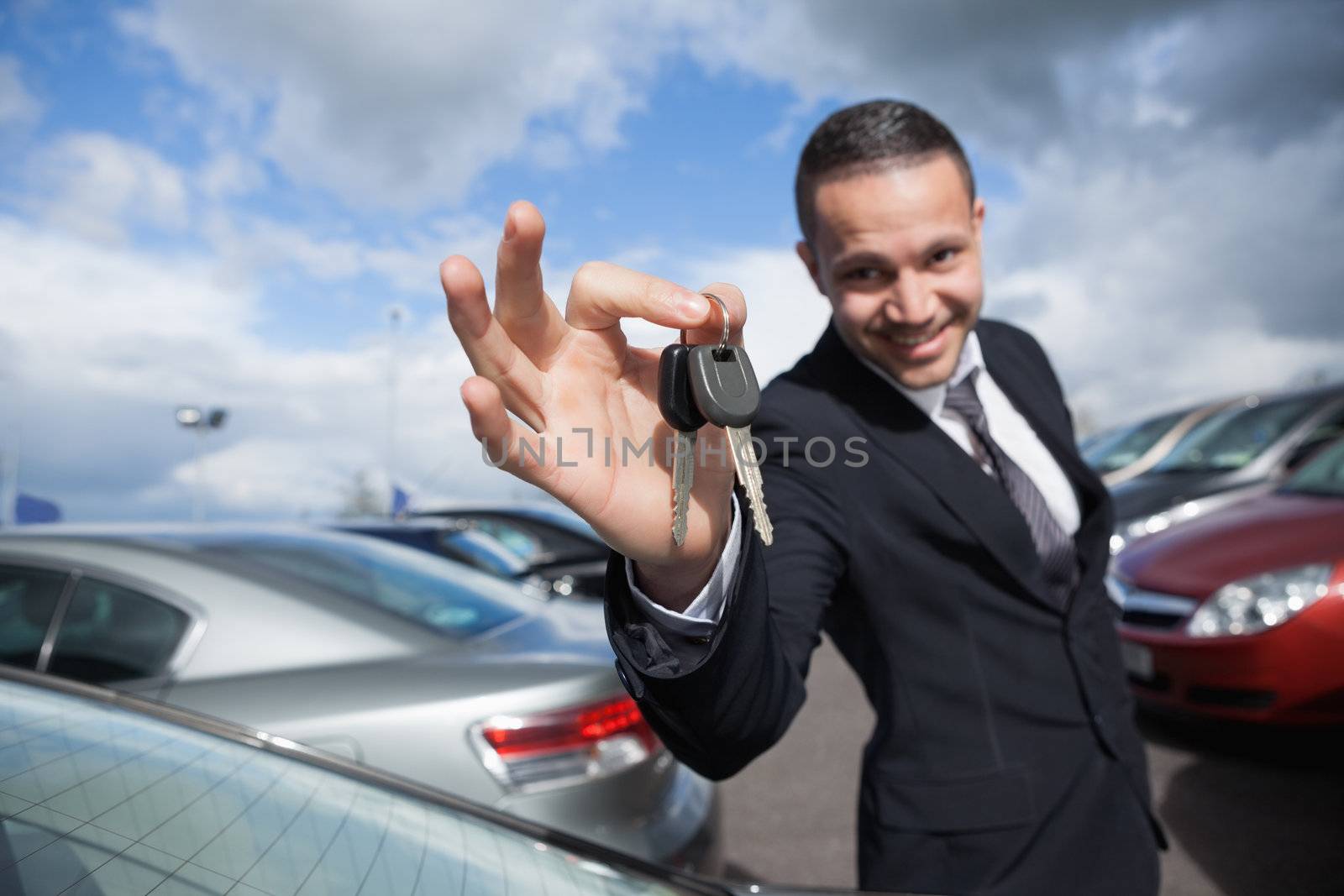 Happy dealer holding car keys by Wavebreakmedia