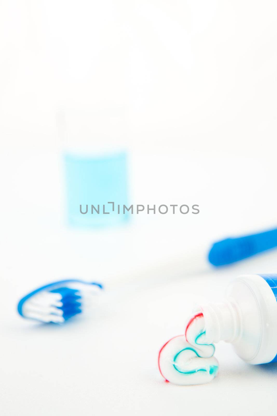 Multicolour toothpaste outgoing of a toothpaste tube against white background