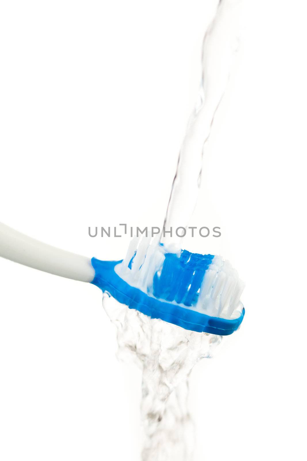 Water flowing on a toothbrush against white background
