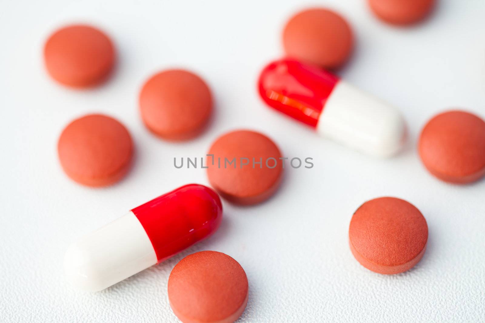 Some of pills spilled against white background