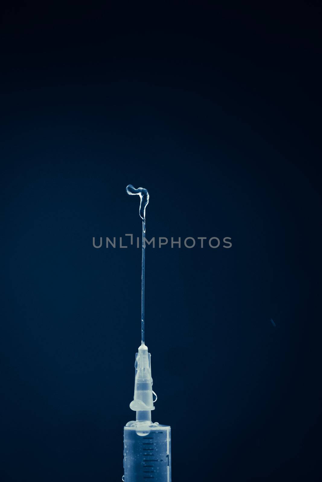 Syringe expelling liquid by Wavebreakmedia