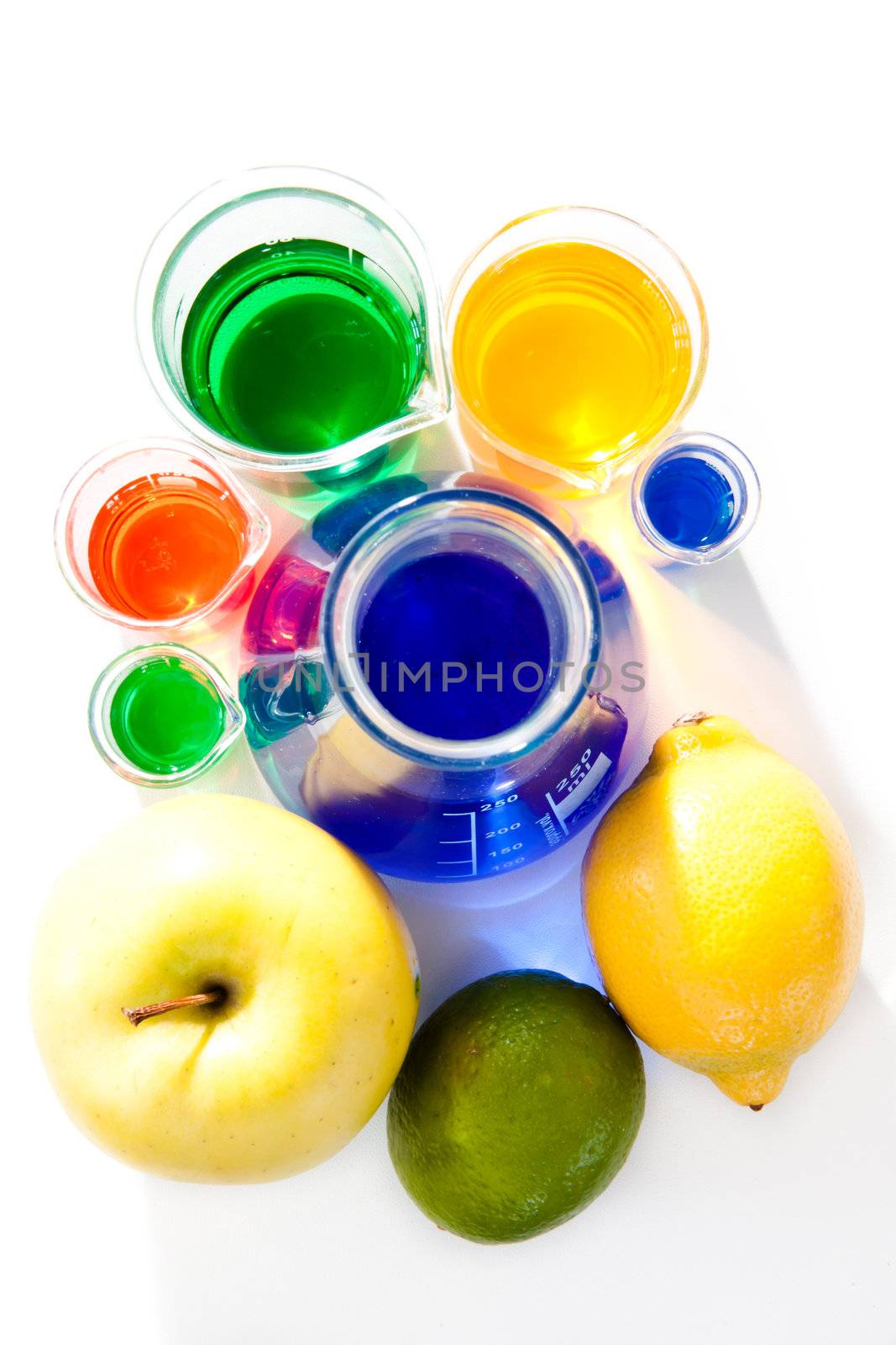 Fruits and beakers against a white background