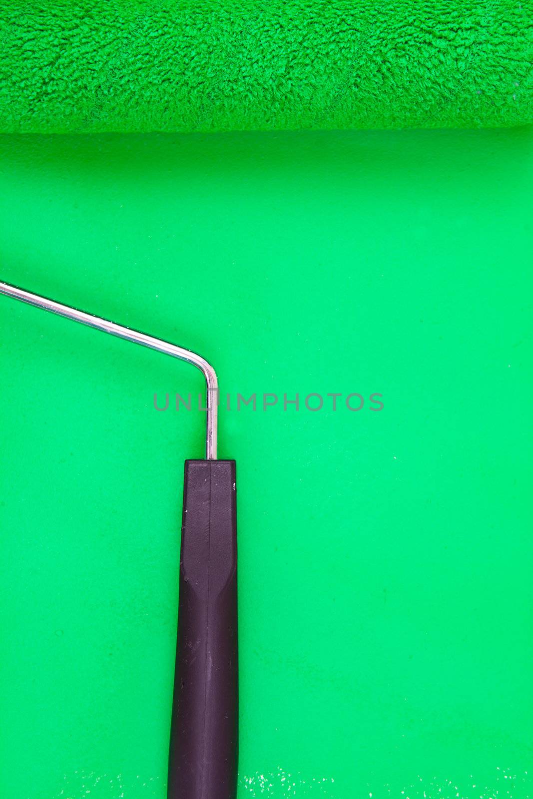 Green paint roller with handle on a background