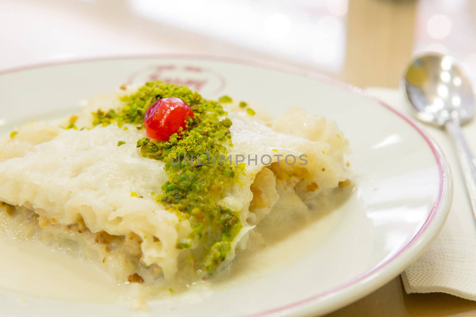 Traditional Turkish Ramadan dessert Gullac made with Phyllo Dough and sweetened milk, served with pistachio crumble and complimented with a piece of cherry.