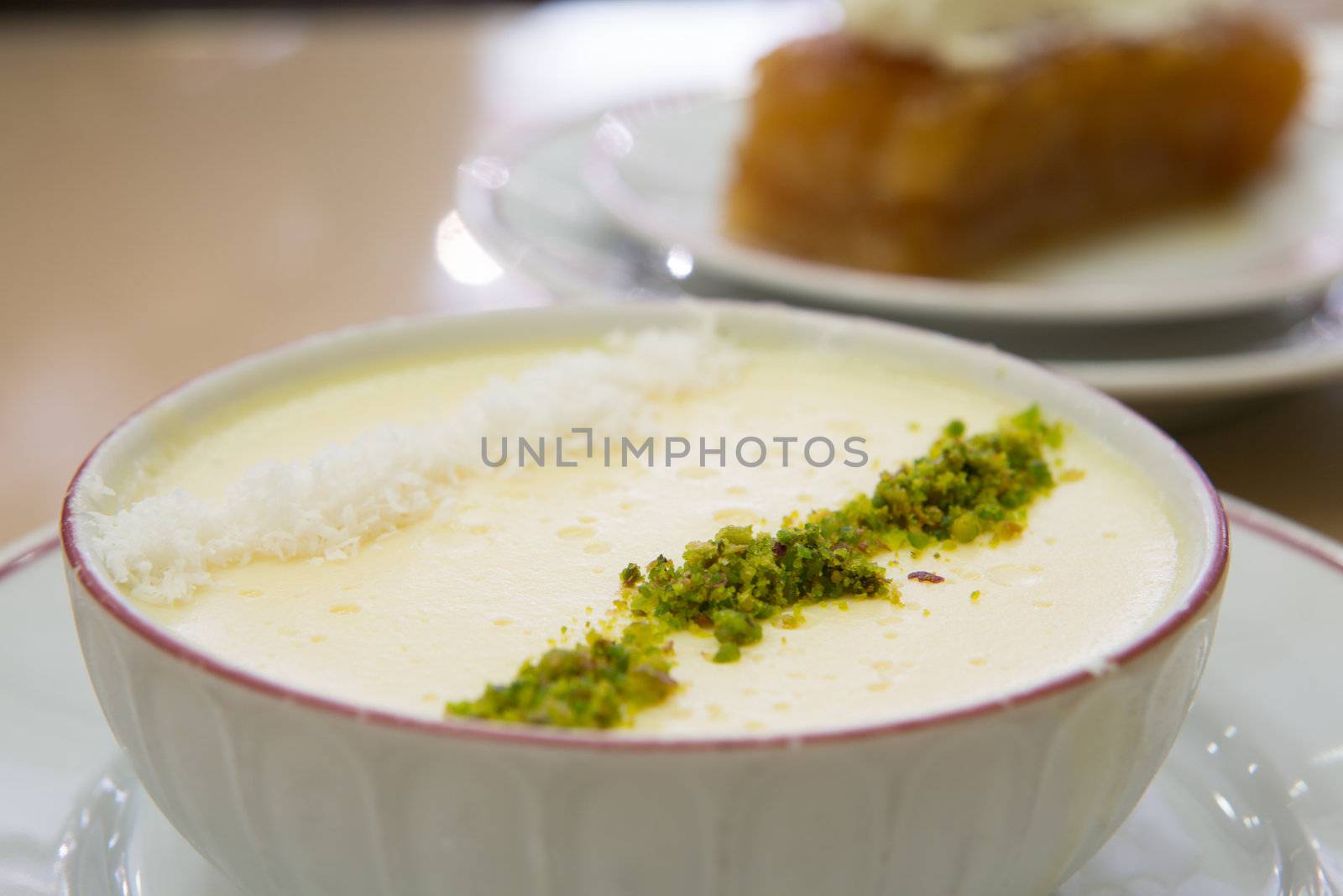 Traditional Turkish dessert Sutlac made with milk, rice and flour, served with pistachio and coconut crumbles.