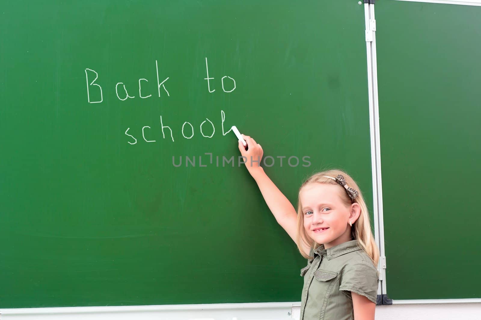 Schoolgirl writing on a blackboard by adam121