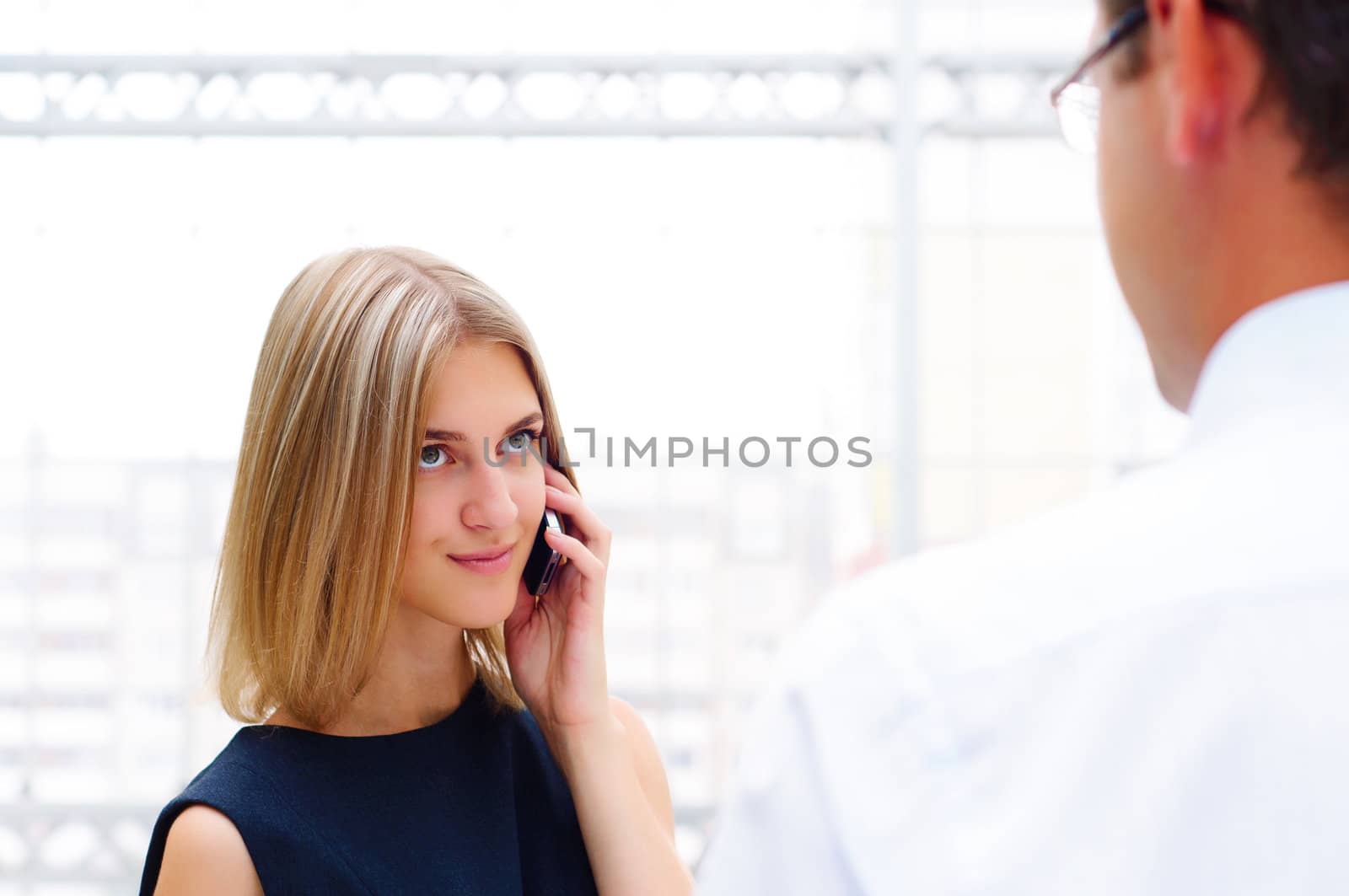 business male and business female discuss reports, Woman talking on cell phone