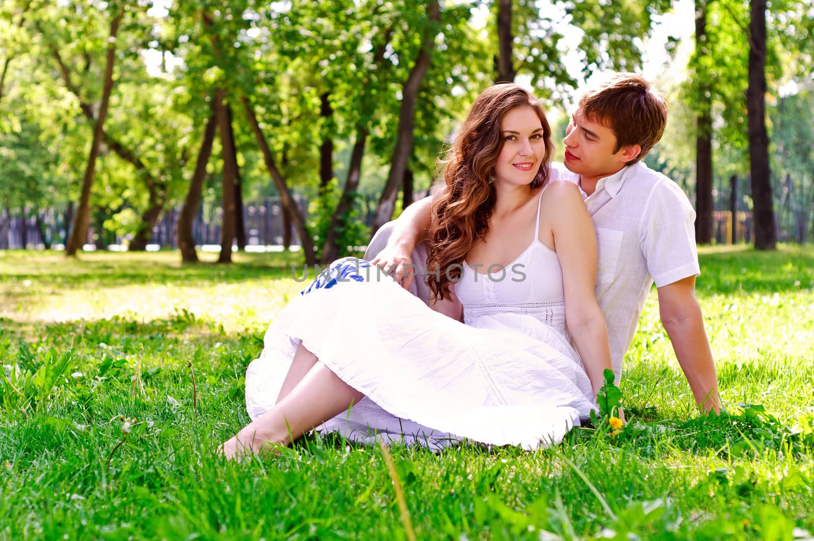 couple in the park sitting on the grass, have a good time together