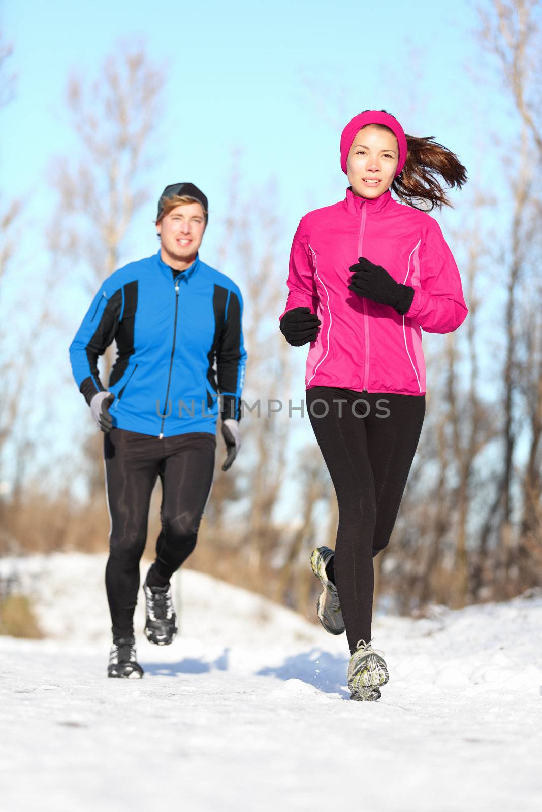 Young couple jogging in winter snow by Maridav